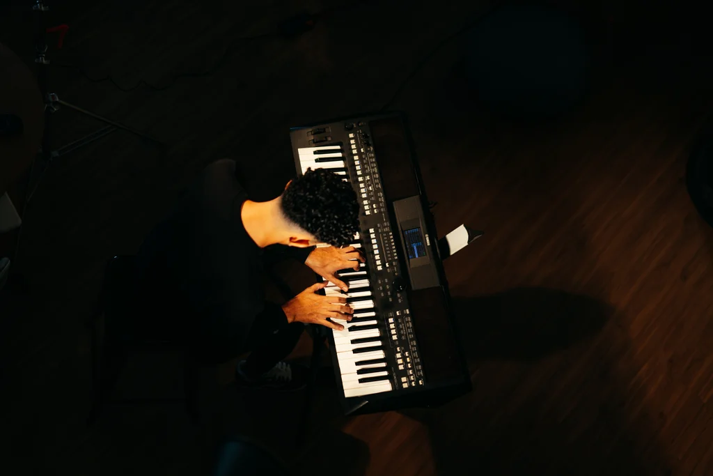 Mãos tocando um teclado arranjador
