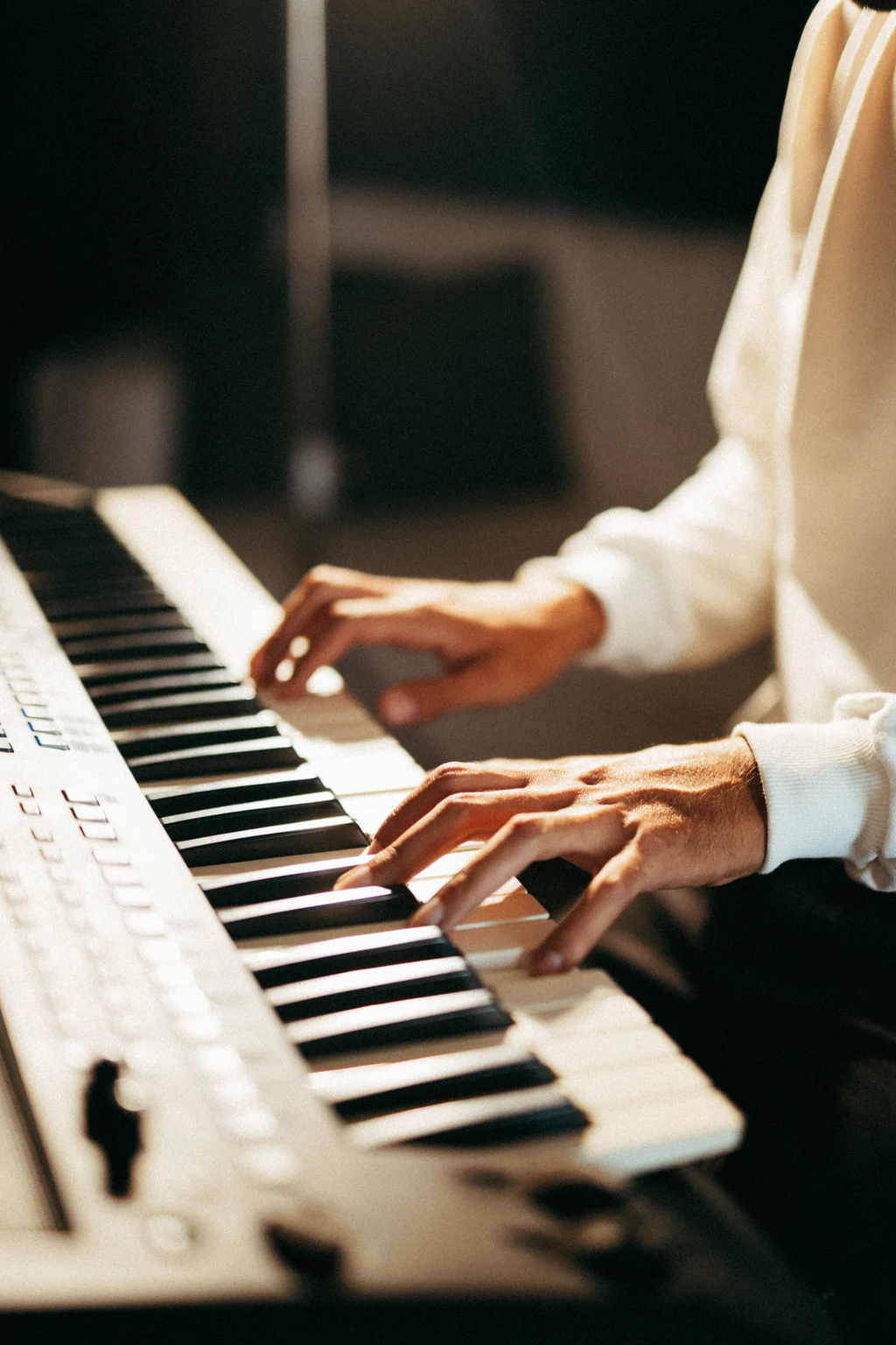 Mãos tocando um teclado arranjador