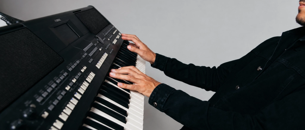 Mãos tocando um teclado arranjador