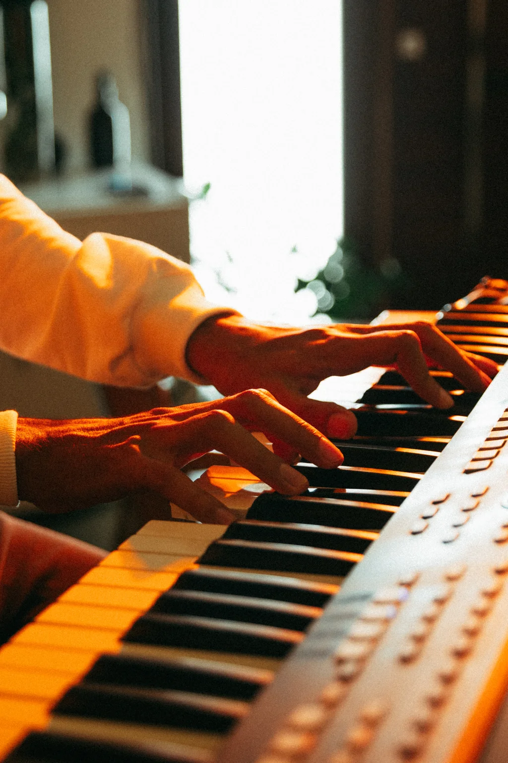 Mãos tocando um teclado arranjador